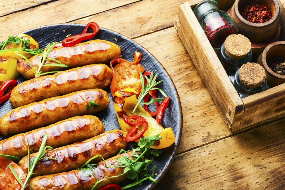 Grilled pork sausages on the plate.Fried sausages and vegetables. Grilled barbecue sausages