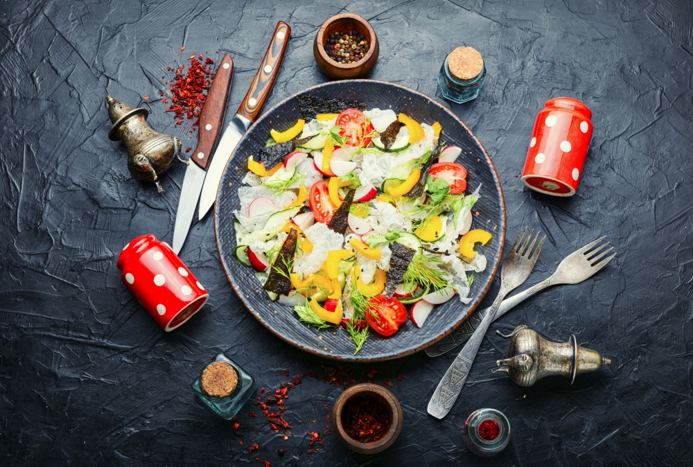 Spring fresh vegetable salad on rice paper.Vegetable oriental salad.. Vegetarian spring salad with fresh vegetables,top view