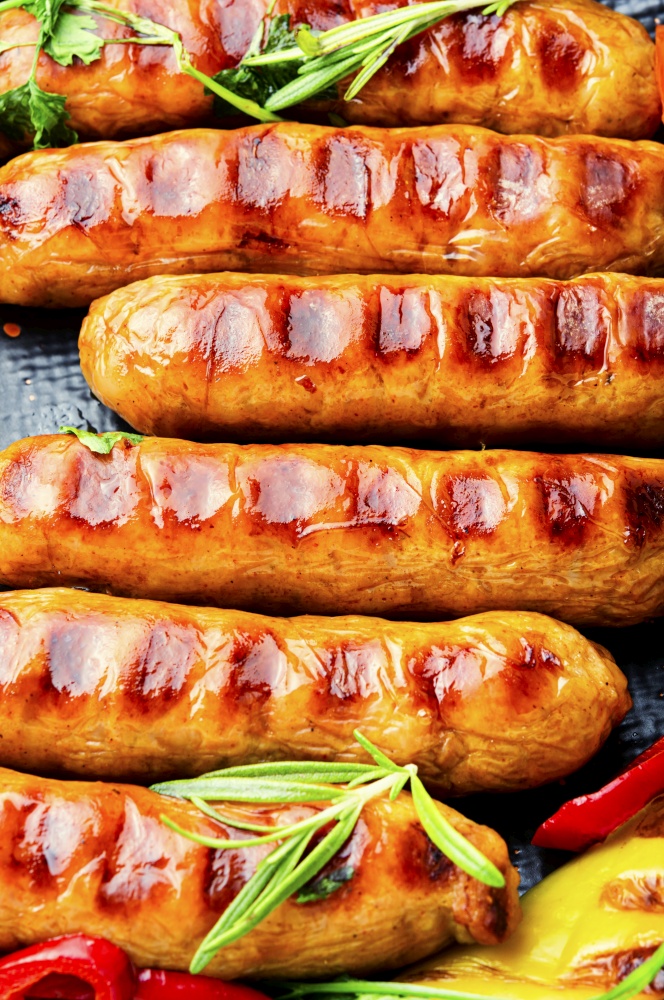 Grilled pork sausages on the plate.Fried sausages with rosemary. Grilled barbecue sausages,food background