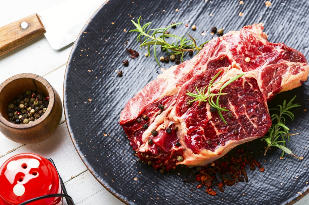 Raw beef meat with rosemary and spices.Uncooked beef steak. Piece of fresh raw beef meat