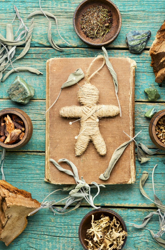 Voodoo doll, magical herbs and witchcraft attributes on an old table. Voodoo doll,a doll used in witchcraft