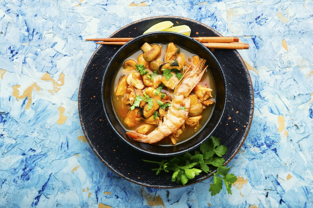 Tom yam kung spicy thai seafood soup in bowl. Tom yum soup with seafood and coconut milk