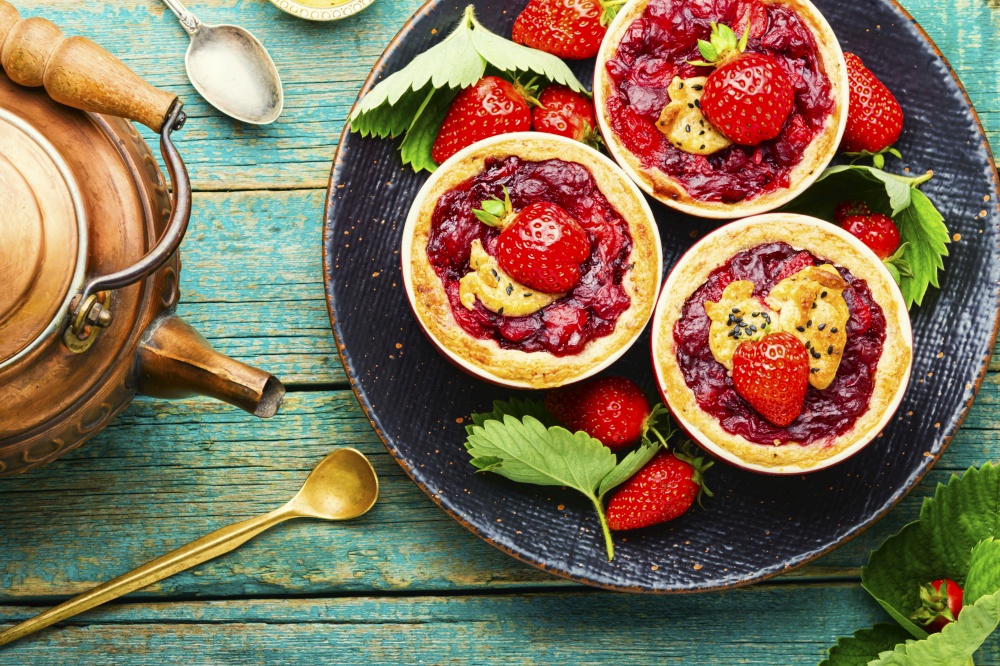 Tasty tartlets with berry jam.Cake with strawberries.Sweets for tea. Summer biscuit or shortcake with strawberries,top view