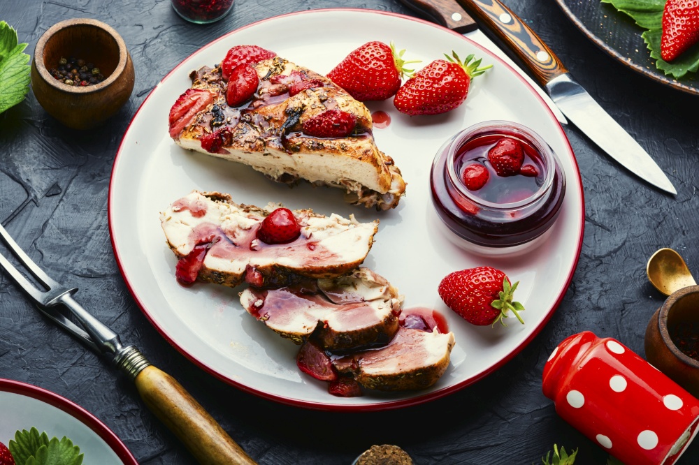 Sliced chicken breast with strawberry berry sauce on the plate.Chicken meat roasted with strawberries,keto diet. Chicken meat baked with strawberry