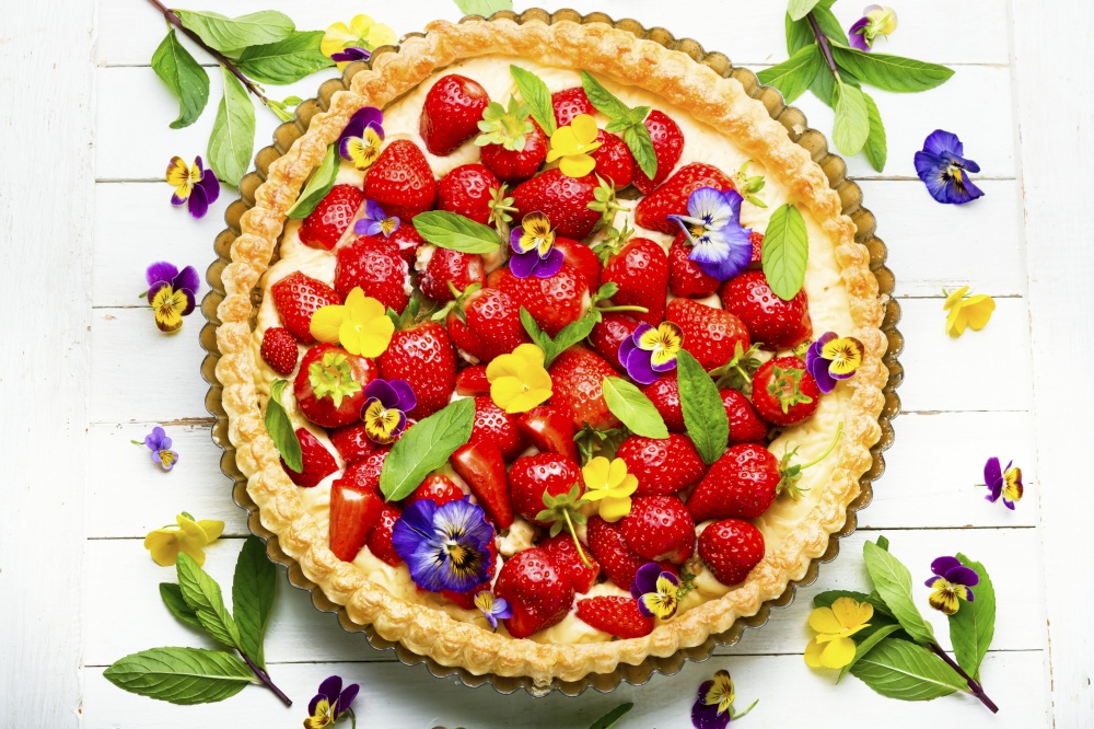 Strawberry pie decorated with mint leaves and flowers. Traditional strawberry pie or tart,top view