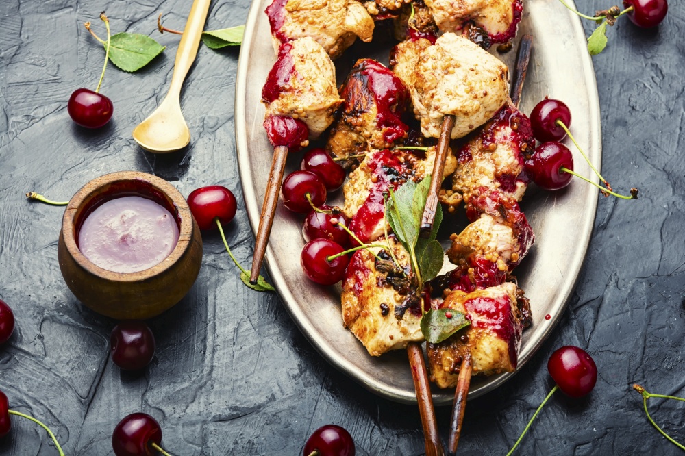Chicken meat on wooden skewers in cherry marinade. Poultry skewers in cherry sauce