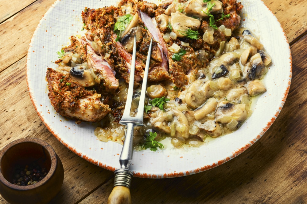 Turkey meat in cheese breading with mushroom sauce. Turkey schnitzel with fried mushrooms
