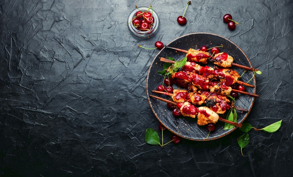 Chicken meat on wooden skewers in cherry marinade.Space for text. Poultry skewers in cherry sauce