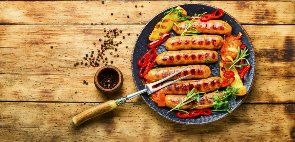 Delicious grilled sausages with grilled vegetables. Sausages fried with pepper.Copy space. Delicious grilled sausages,space for tex