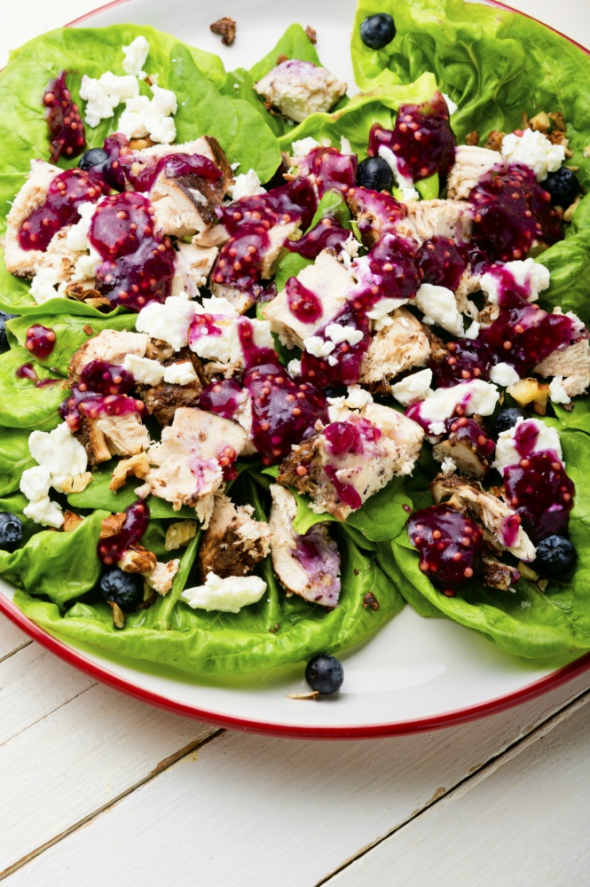 Salad with herbs, grilled chicken, nuts and blueberries.Healthy food. Chicken breast salad, greens, blueberries