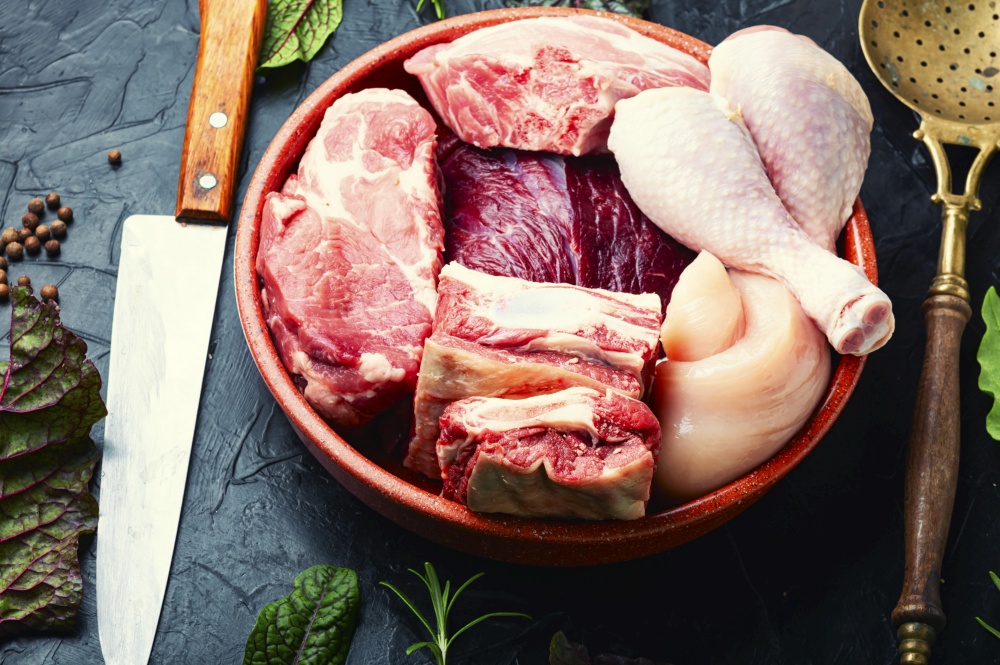 Assortment of fresh raw meat. Beef, pork and chicken meat on the kitchen table.. Raw meat set