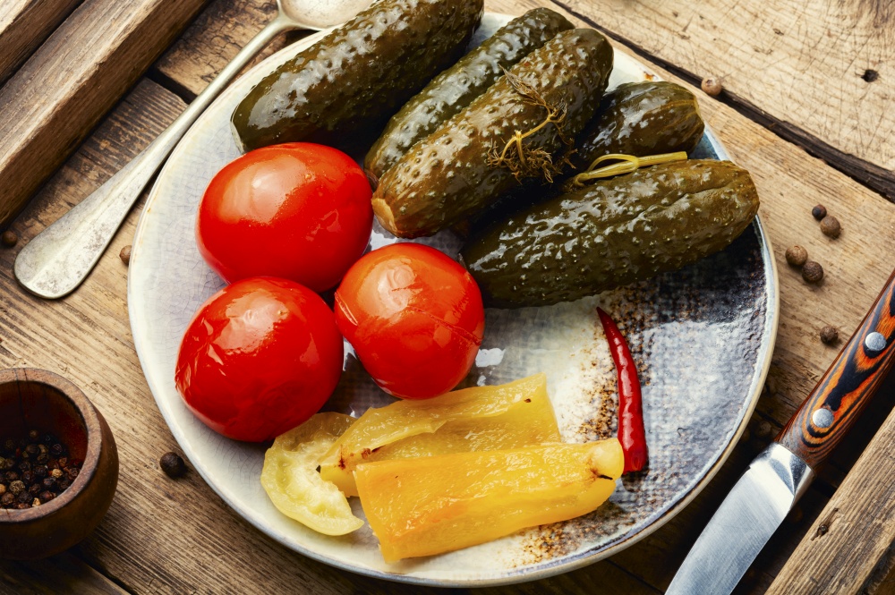 Tasty pickled cucumbers and tomatoes, homemade pickles. Salty vegetables. Salted, pickled vegetables