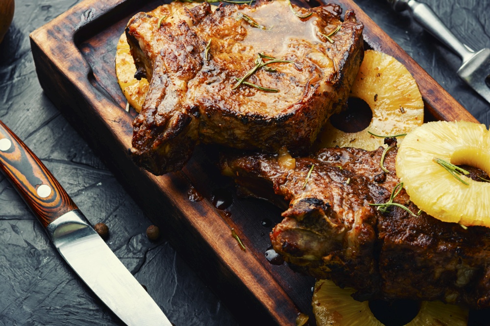 Delicious beef entrecote grilled with pineapple on cutting board. Beef fried with pineapple