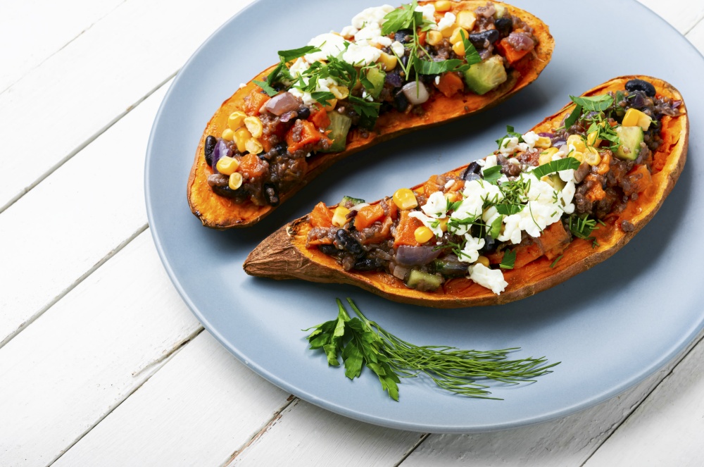 Tasty batata halves baked with vegetables and cottage cheese. Sweet potato. Sweet potato or yam baked with vegetables.