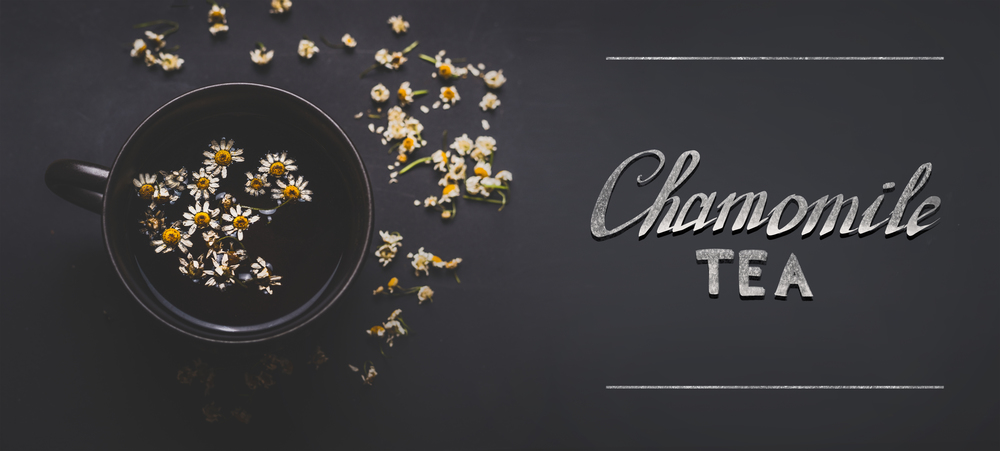 Cup of herbal chamomile tea with  dried chamomile flowers and text  on dark background, top view. Remedy to treat a wide range of health issues. Herbal medicine concept. Healing herbs .