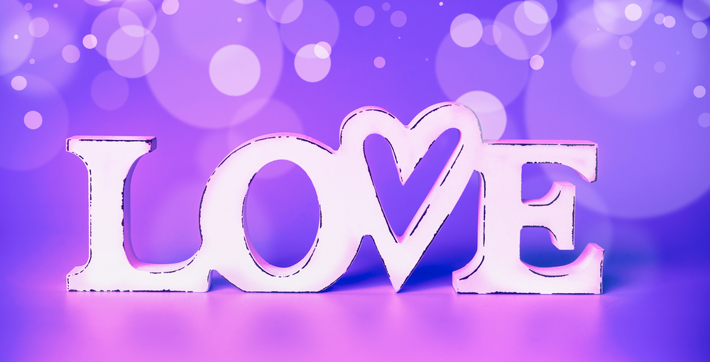 White word love at neon color bokeh background