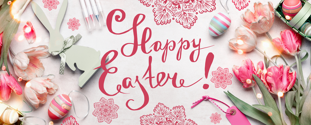 Happy Easter card. Various Easter eggs, markers and handicraft decoration accessories with fresh tulips flowers on white background, top view, flat lay. Handwritten-style text lettering