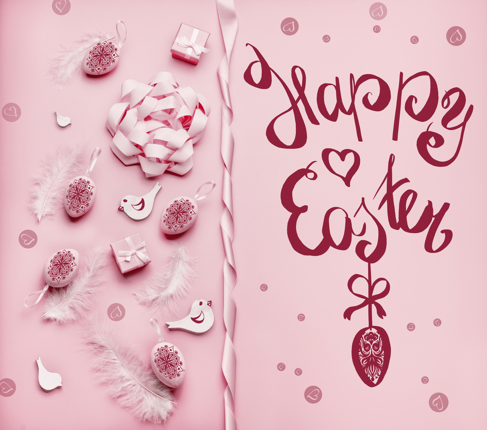 Happy Easter greeting card with eggs, feathers and ribbons at pink background, top view, with copy space for your design. Flat lay . Handwritten text lettering