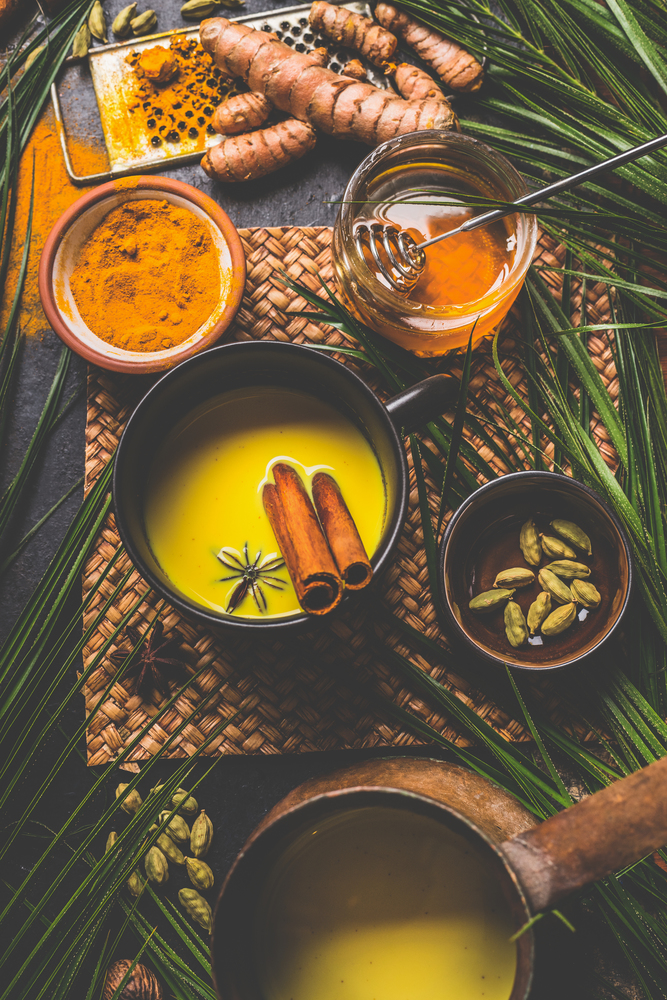 Healthy turmeric milk drink made with turmeric roots , spices and honey. Hot winter beverage. Immune boosting remedy , detox and dieting concept