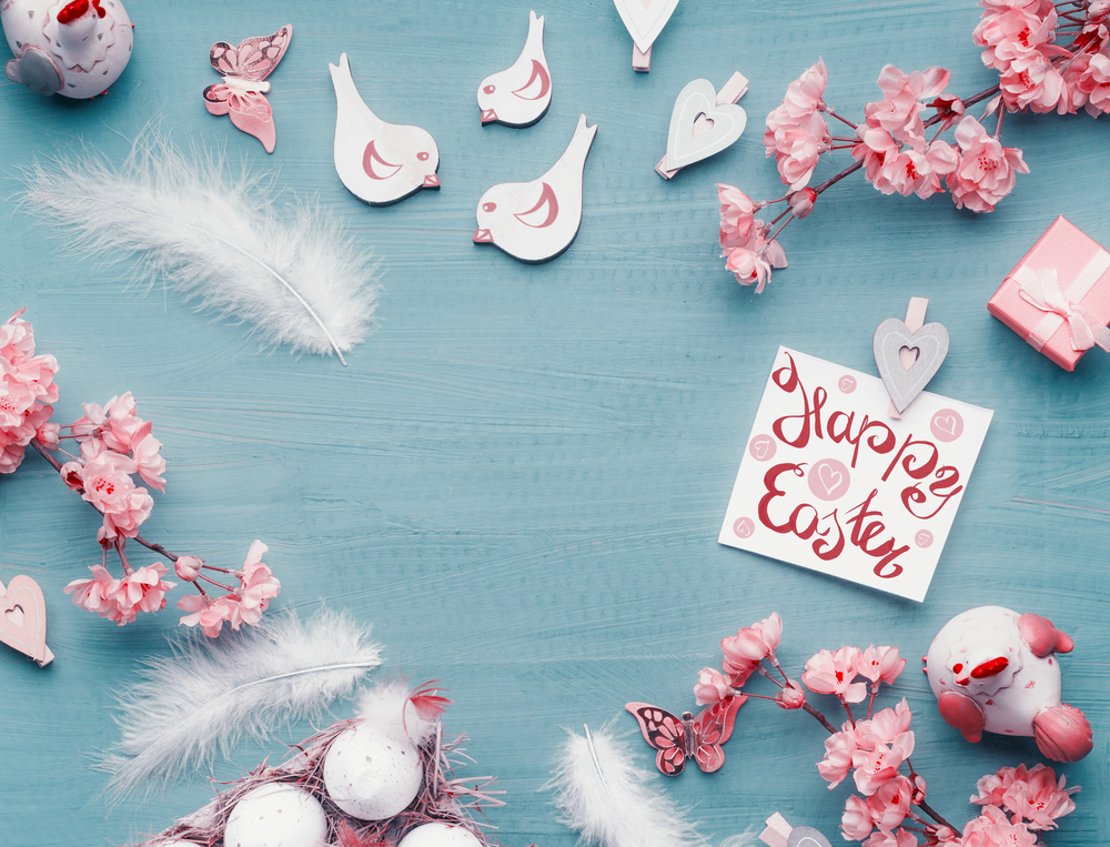 Easter background with Happy Easter card, eggs, spring blossom and decoration, top view, frame