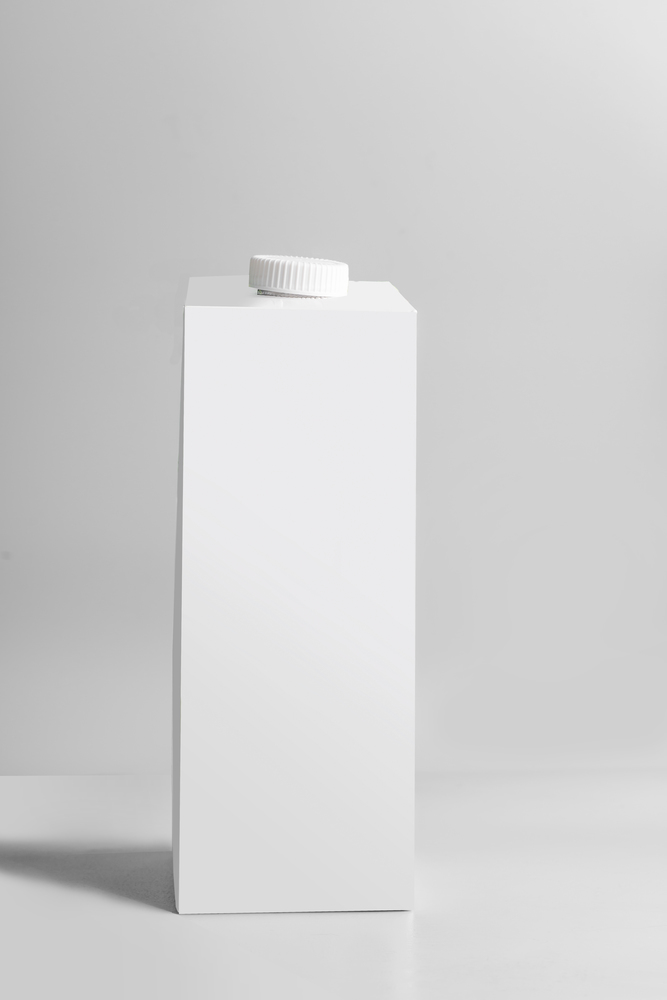 White packaging tetra-pack standing on light gray background, front view. Empty template box milk or juice. Package branding mock-up