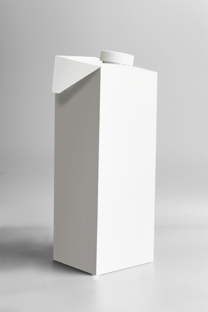 White packaging tetra-pack standing on light gray background, front view. Package branding moc-up. Empty template box milk or juice