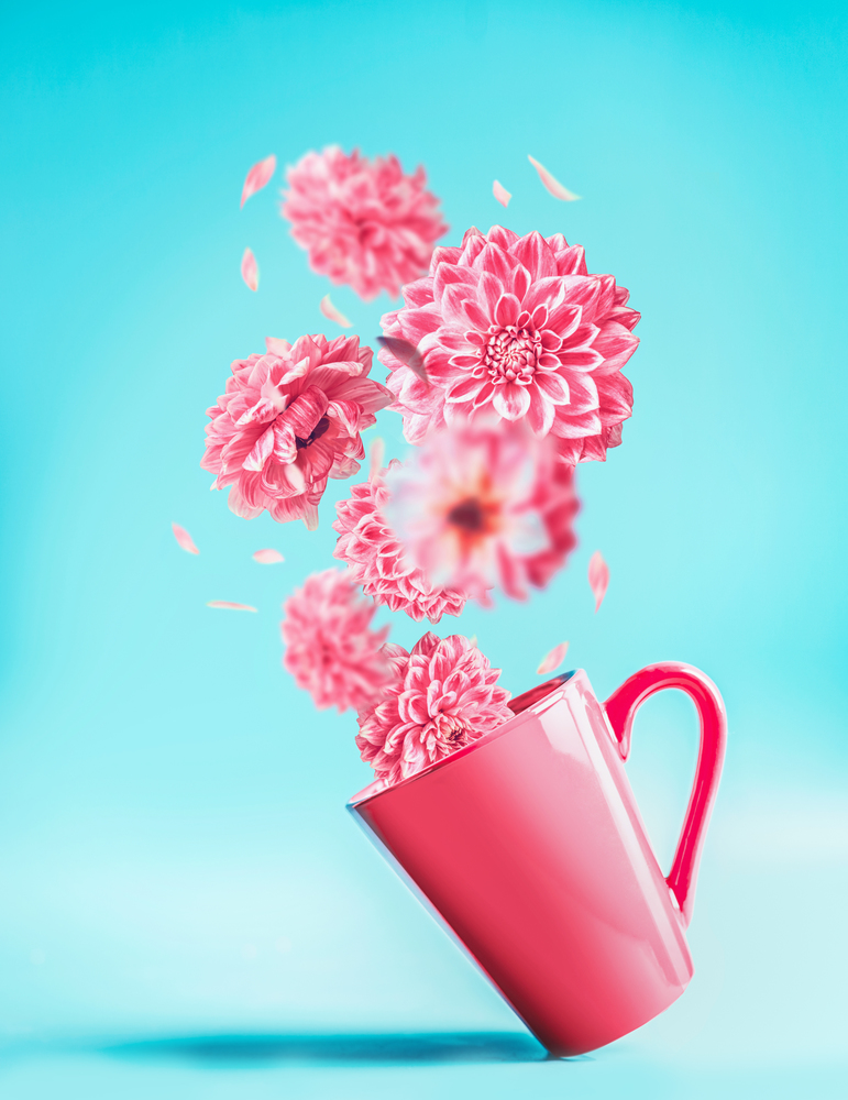 Pink cup with pretty flying flowers at turquoise blue background. Creative floral arrangement. Falling flowers. Birthday, Mother&rsquo;s, Valentines, Women&rsquo;s, Wedding Day concept. Vertical. Copy space