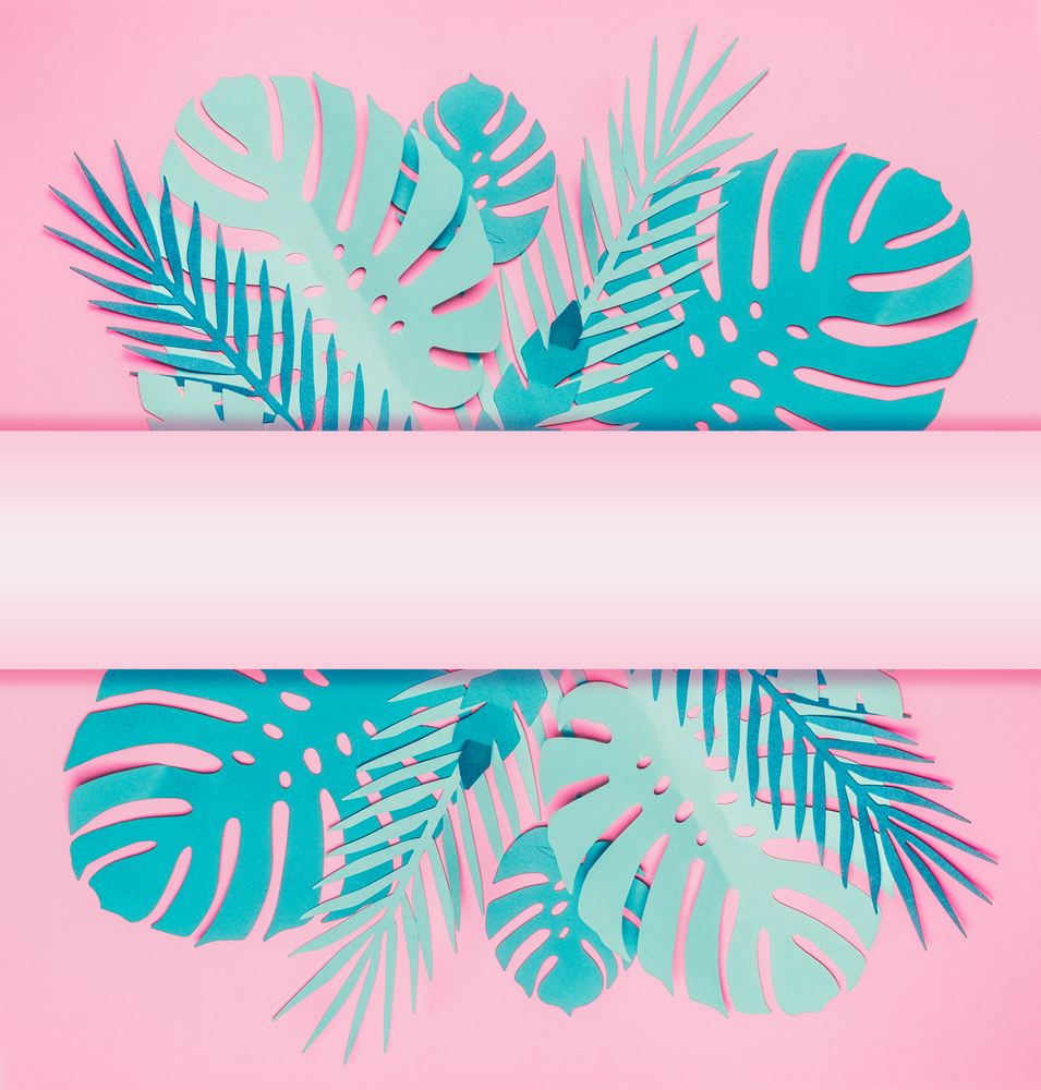 Various turquoise blue tropical leaves with copy space for your design on pastel pink background. Creative layout