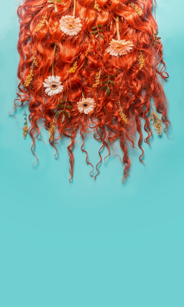 Red ginger curved hair background with flowers on turquoise blue background. Beauty and hair styling concept.