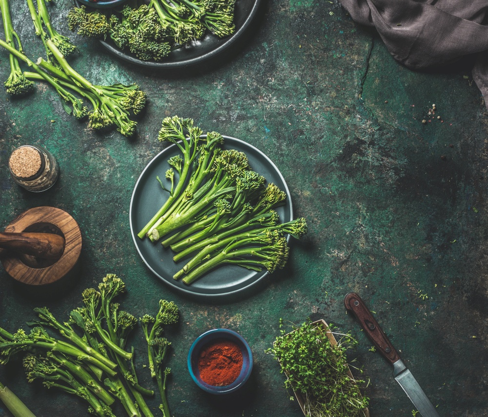 Wild broccoli on dark rustic background . Cooking preparation. Top view. Healthy food