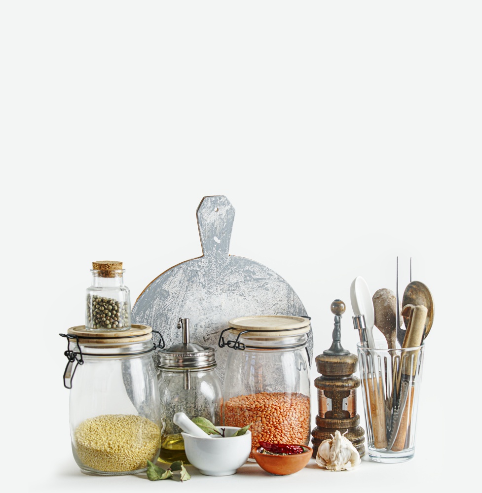 Sustainable kitchen setting with housekeeping jars and eco friendly kitchen utensils at white background. Front view. Modern still life