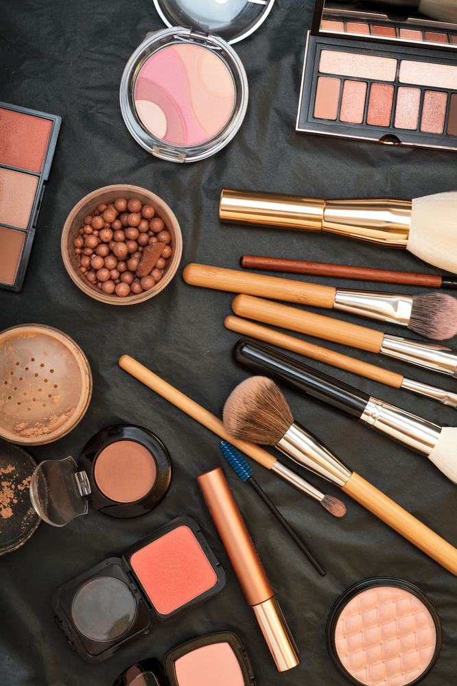 Set of make up brushes  with cosmetics on black background