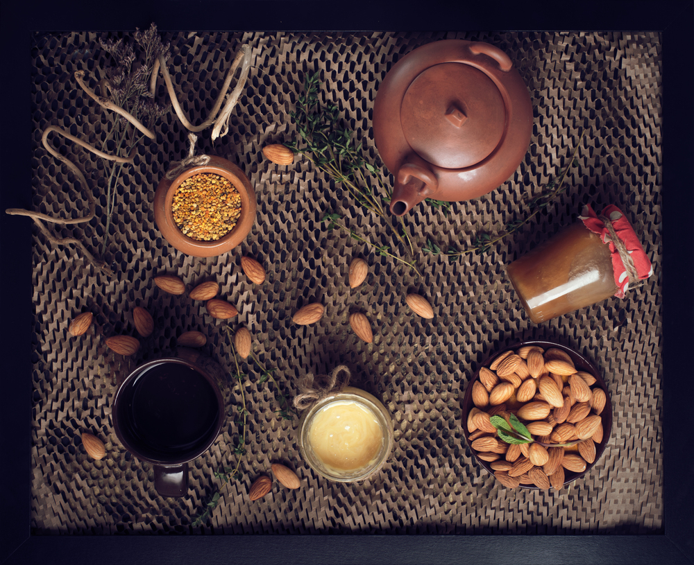 flat lay still life with honey and pollen and nuts