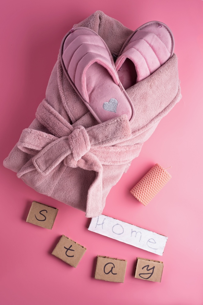 cozy home set with slippers and bathrobe against pink background. concept composition