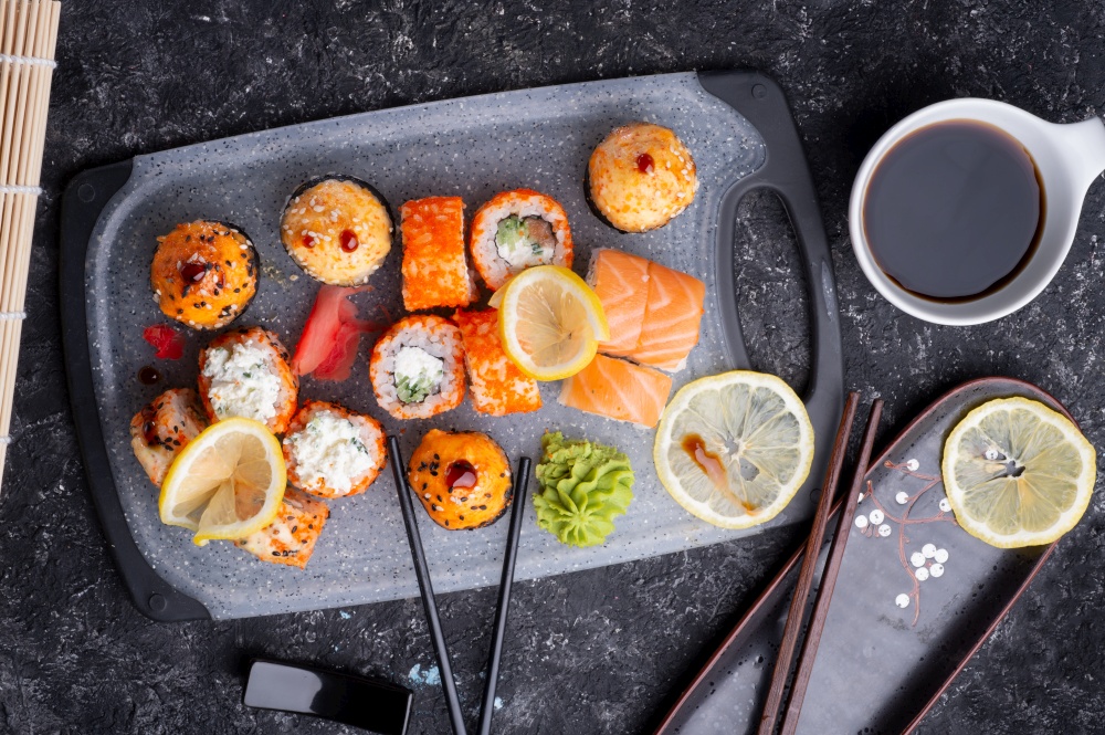 sushi roll set served at grey tray at black table. flat lay. close up
