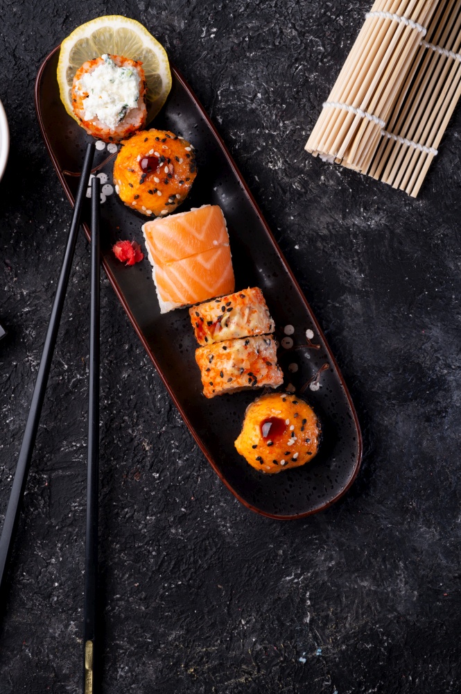 sushi roll set served at black tray at black  table. flat lay. close up