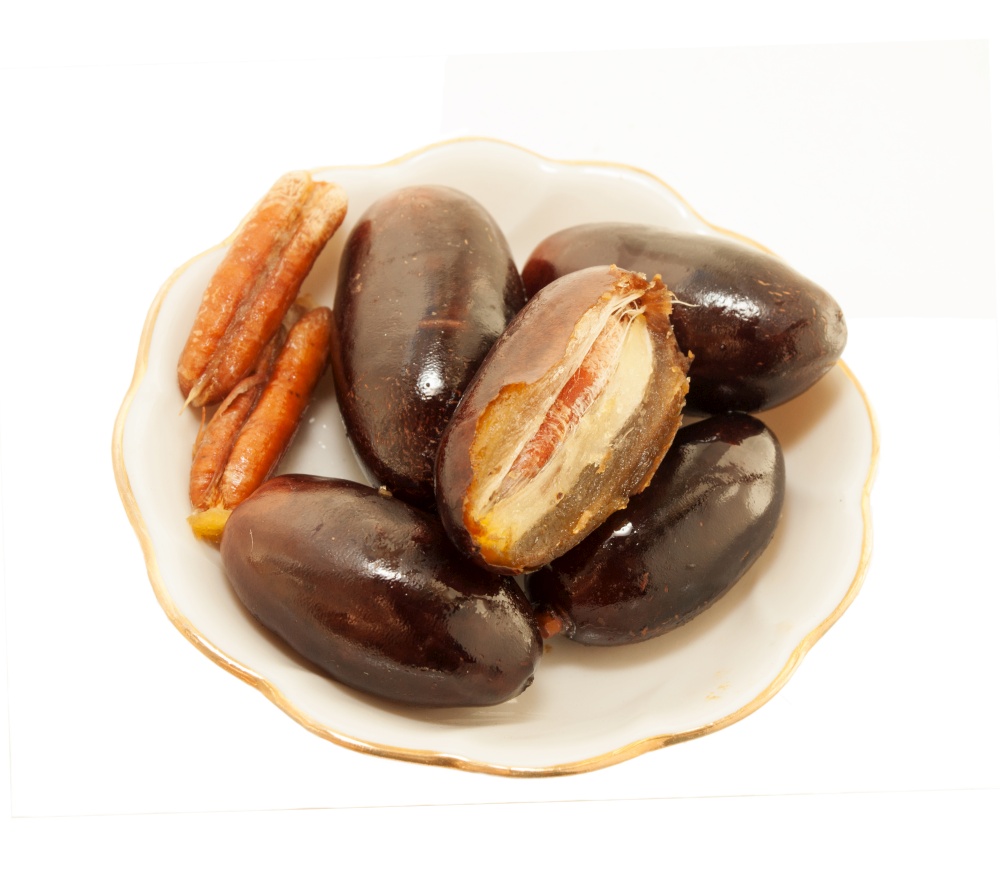 Fresh big dates in saucer isolated on white background. close up