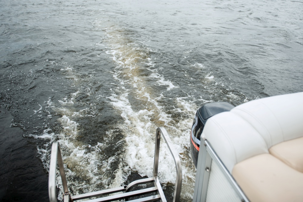 the stern of a motor boat with a bubbling trail of river water