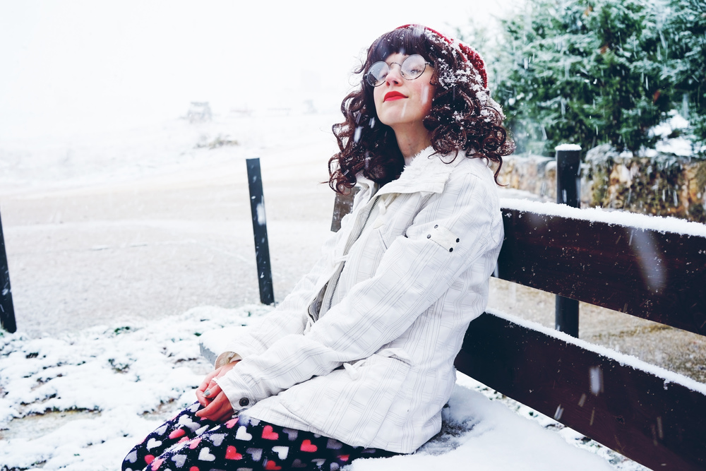 Young and pretty woman enjoying a snowy winter day