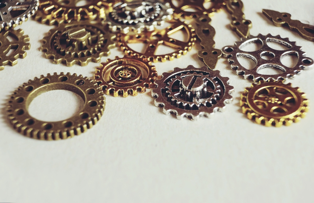 A steampunk and ancient macro about machinery made of bronze, silver and gold gears with beige background