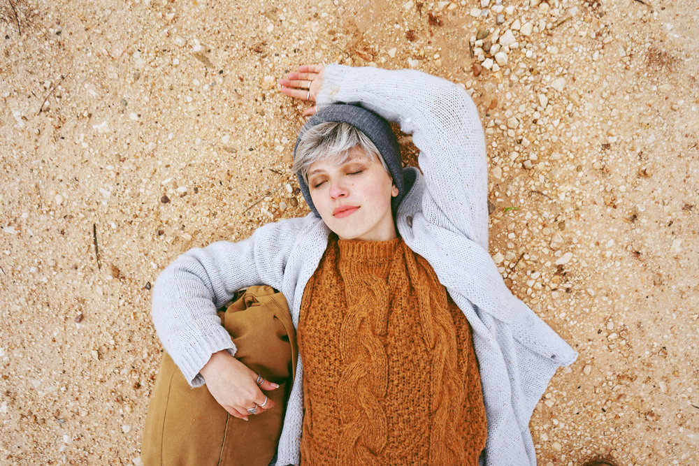Young adventure woman lying in sand