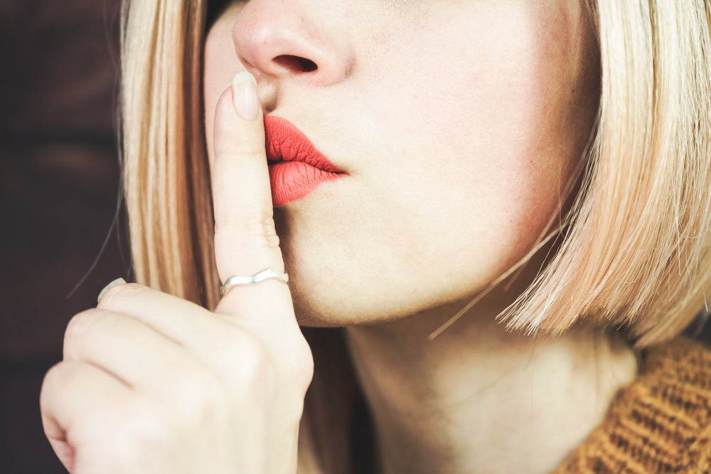 Close up of a beautiful blonde woman doing a silent gesture