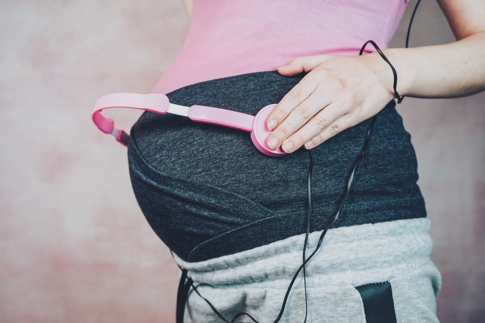 Young mother put music to her baby in her belly during pregnancy