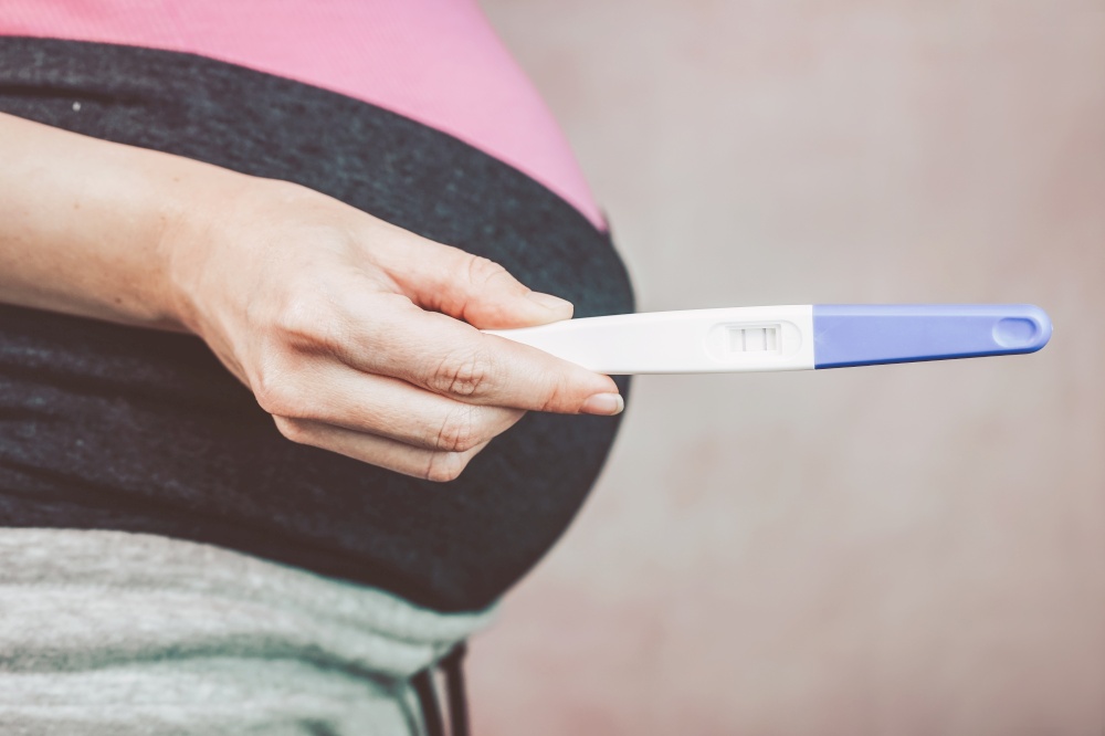 Woman holding a positive pregnancy test