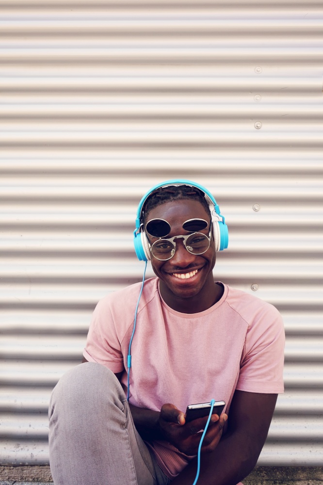 Young happy man listening to music with his smartphone