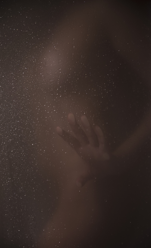 silhouette of a woman in the shower through the glass.