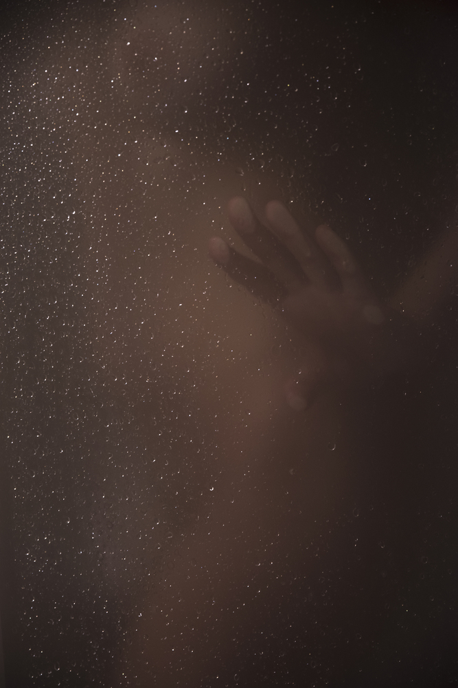 silhouette of a woman in the shower through the glass.