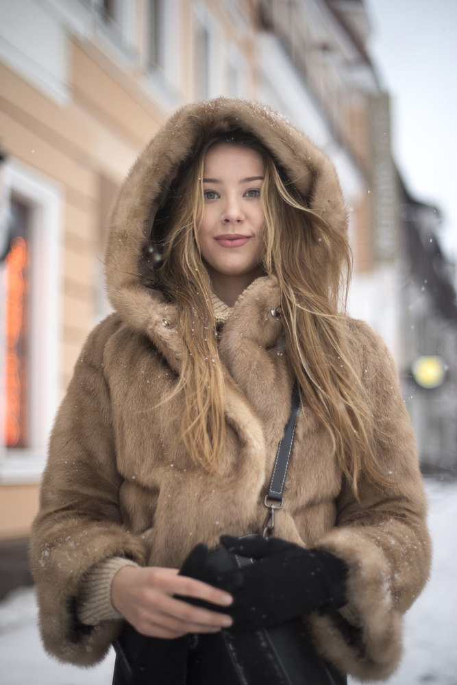 girl in a fur coat walking in the city