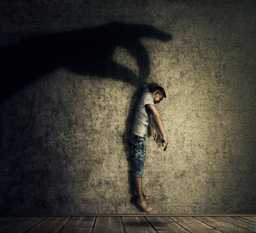 Human hand shadow holding a powerless man hanging. Conceptual image symbolizing manipulation, business control as a marionette.