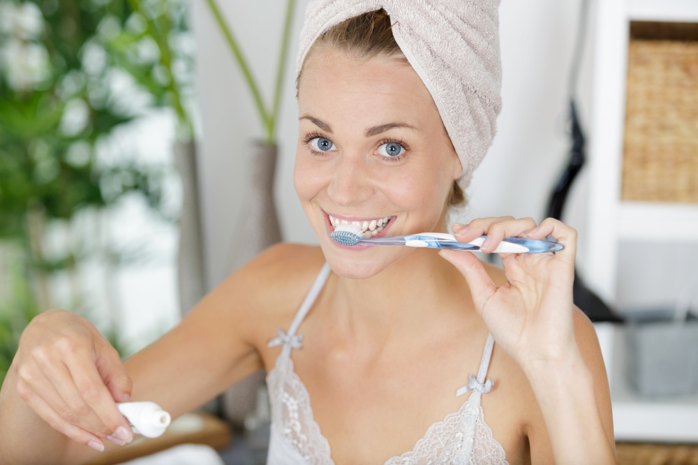 young woman using brushing her teeth